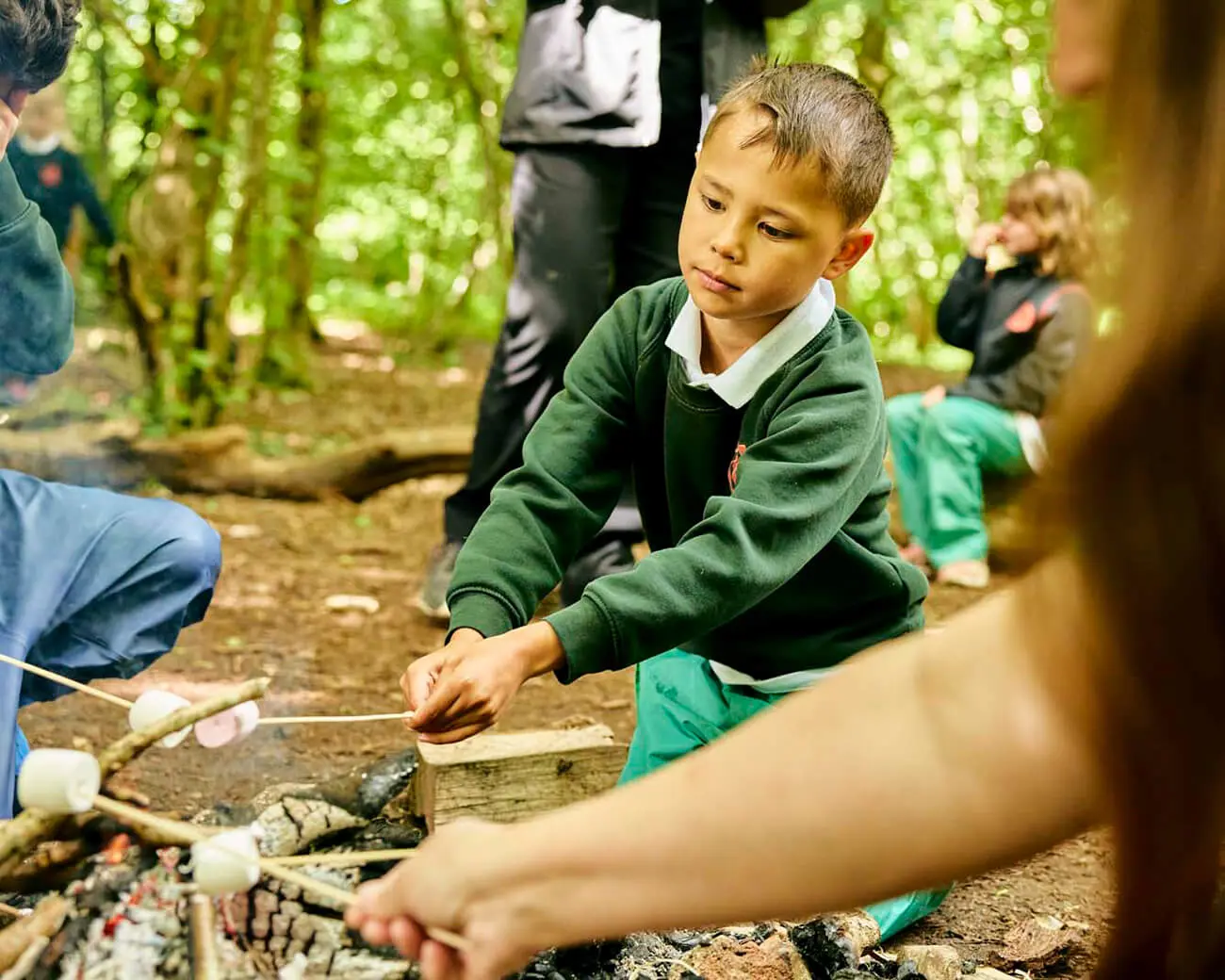 Boy toasting a marshmallow in forest school
