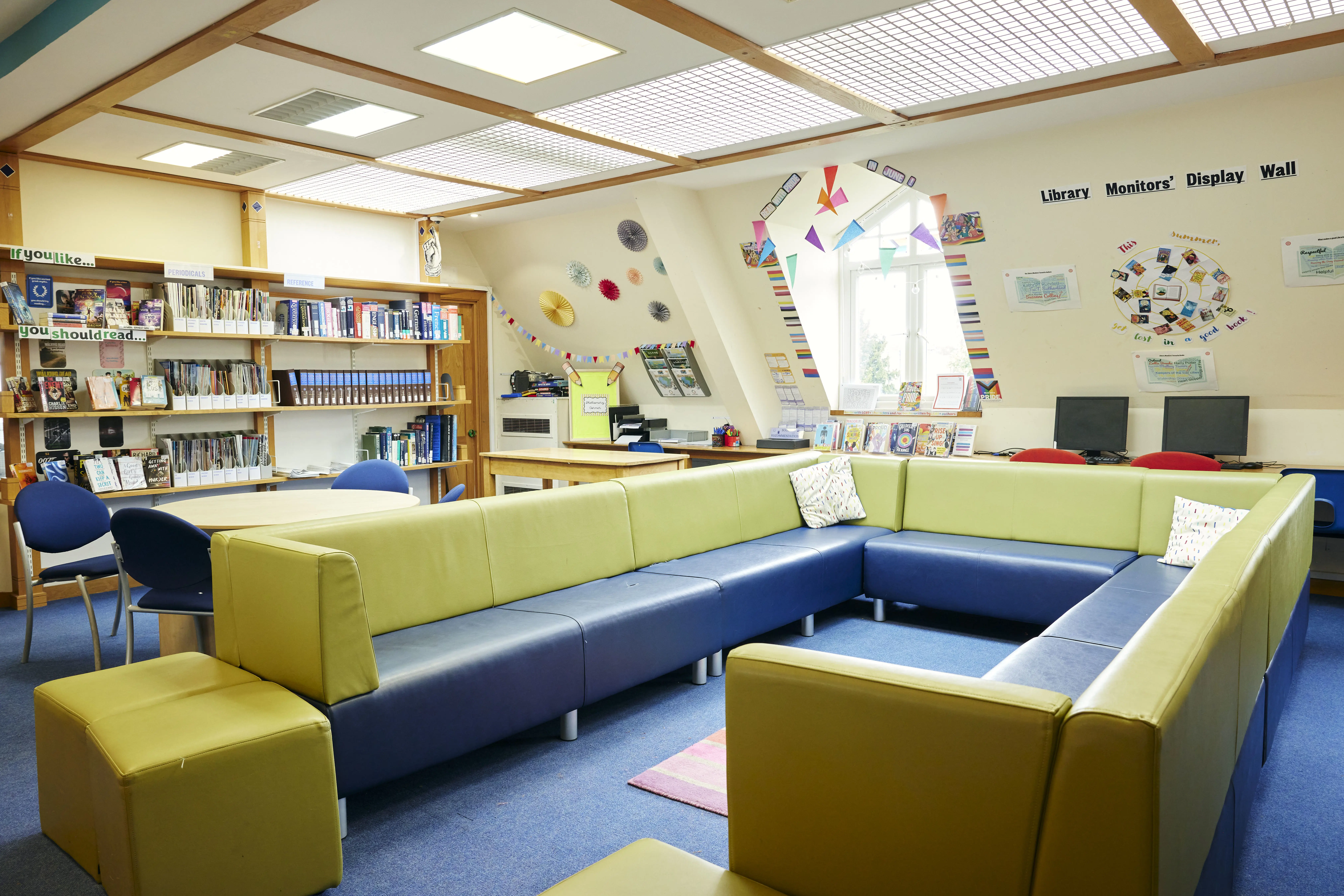 Comfortable seating area within the Senior School Library at Clifton High School, surrounded by bookshelves, study tables and learning resources.