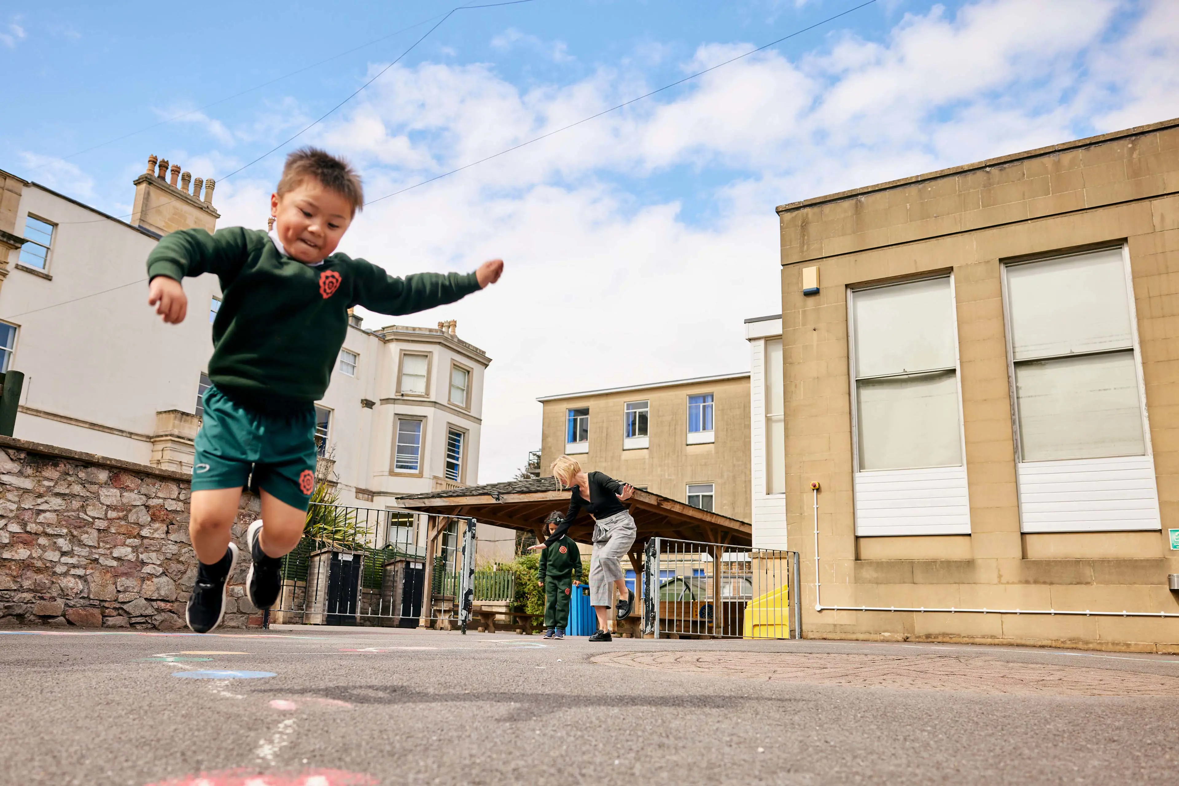 Infant School pupil taking part in outdoor play activities in the playground at Clifton High School.
