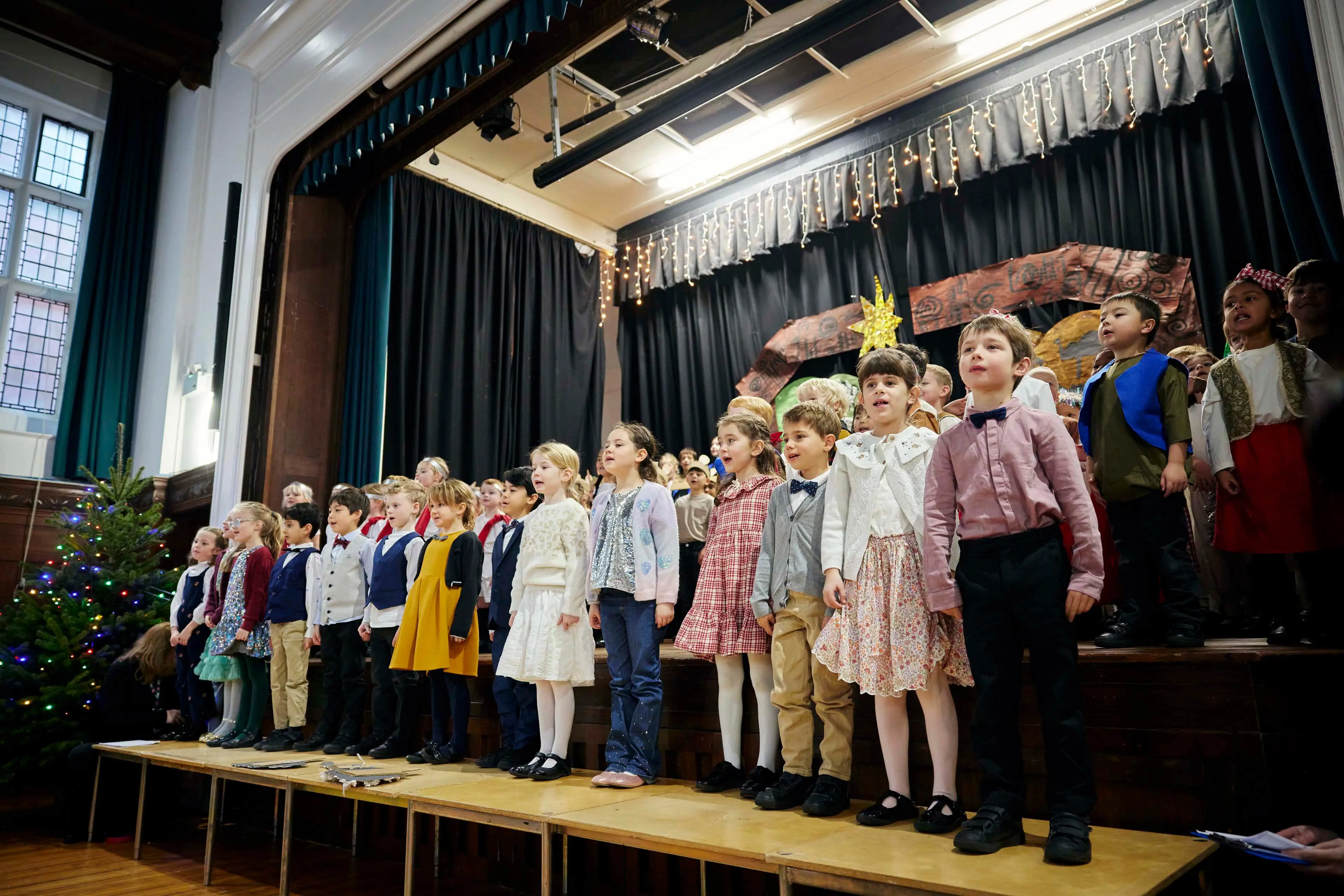 Pupils performing an Infant School Nativity play on stage in the Main Hall at Clifton High School.