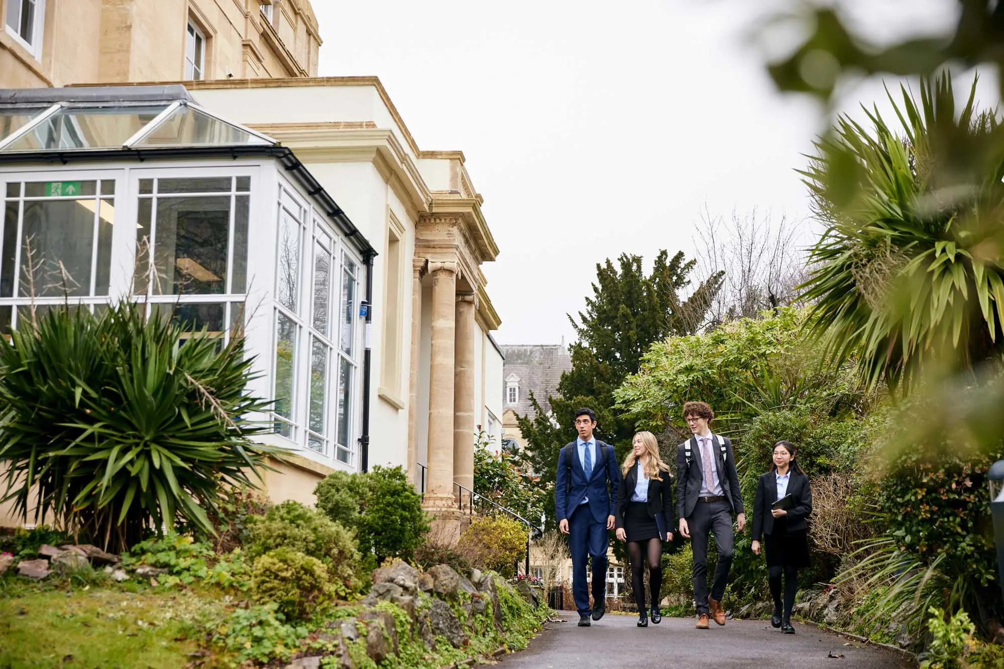 Sixth Form students walking through the outdoor space surrounding Walter's Sixth Form Centre at Clifton High School.